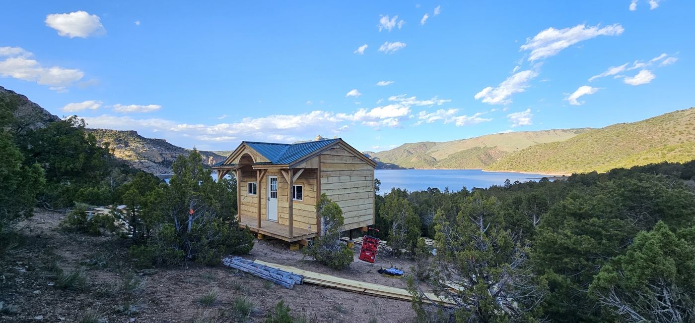 Timber host cabin under construction overlooking a mountain reservoir